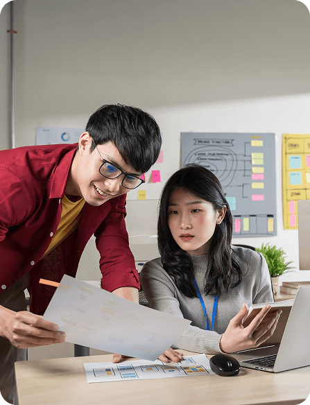 Two Guerilla 360 team members reviewing wireframes at a desk