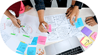Hands sketching wireframes over sticky notes