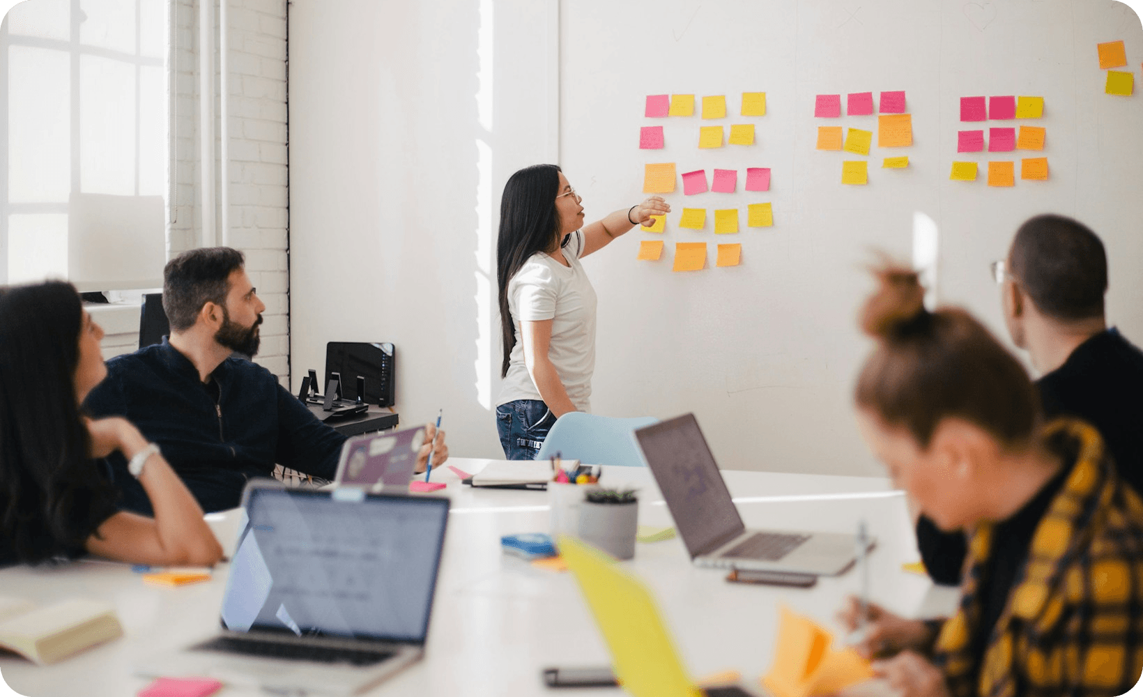 EMAPTA team collaborating around a whiteboard with sticky notes